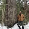 A man standing next to a tree