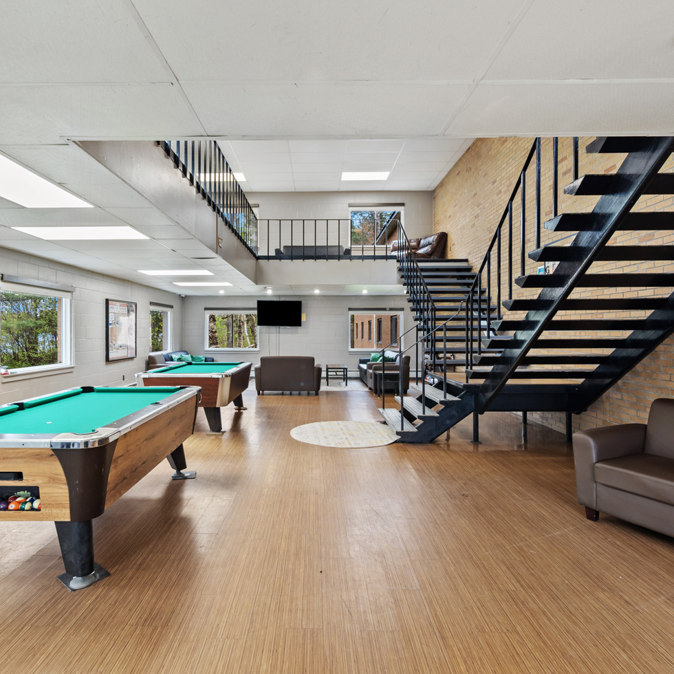 Common area in residence hall with pool tables and stairs