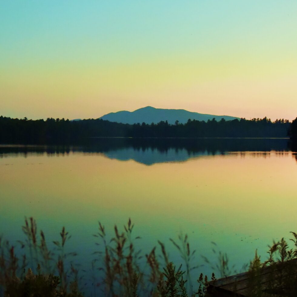 Sun setting over the lake with mountain in the distance