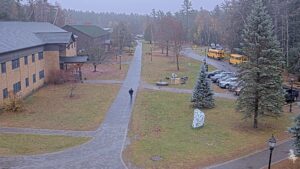 webcam shot of student walking up sidewalk from library