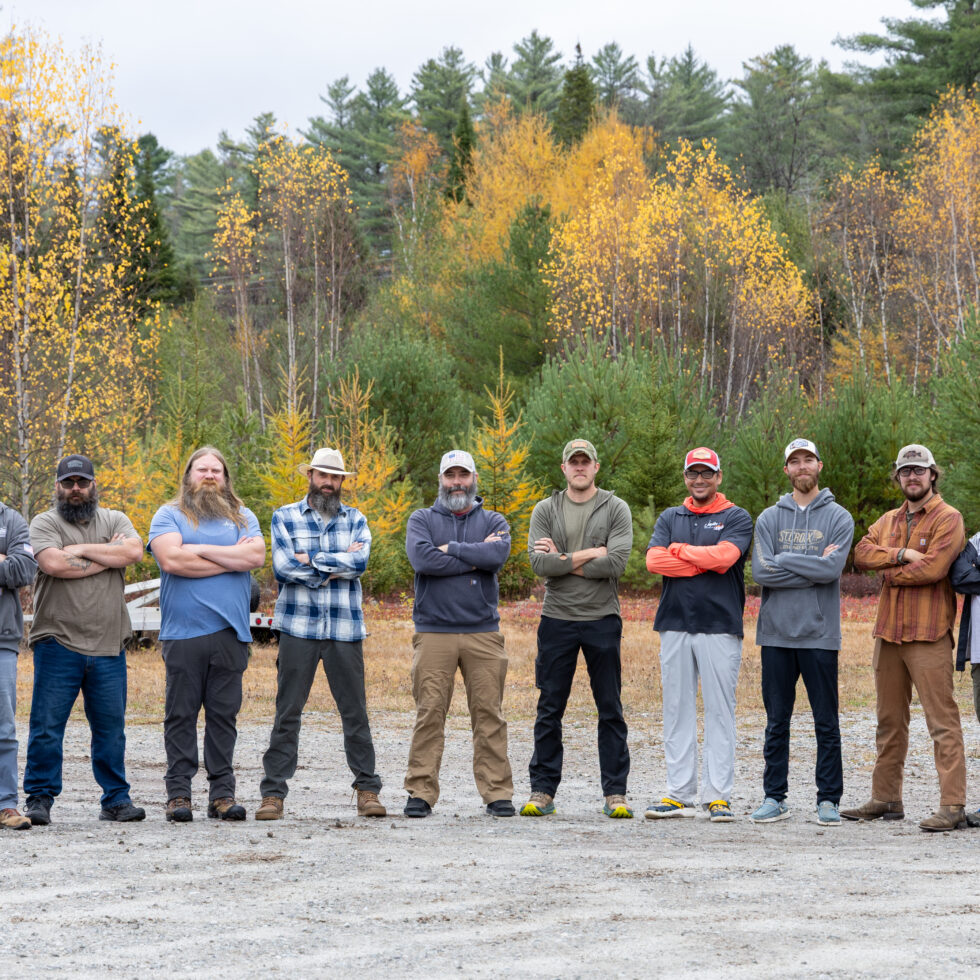 11 men standing in front of a fall backdrop