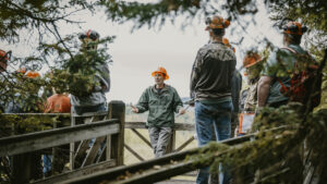 A group of people standing with orange hard hats on