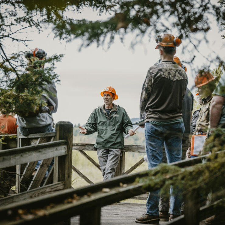 A group of people standing with orange hard hats on