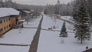 webcam shot of student walking up sidewalk from library