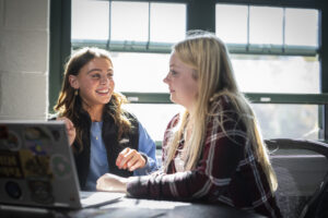 Two people talking at a computer