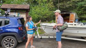 Two people talking by a boat