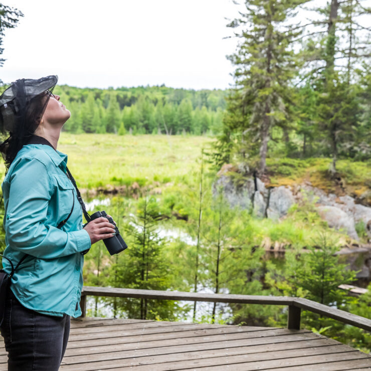 A woman looking up with binoculars
