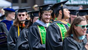 A group of people sitting in caps and gowns