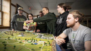 A group of people standing around a diorama table