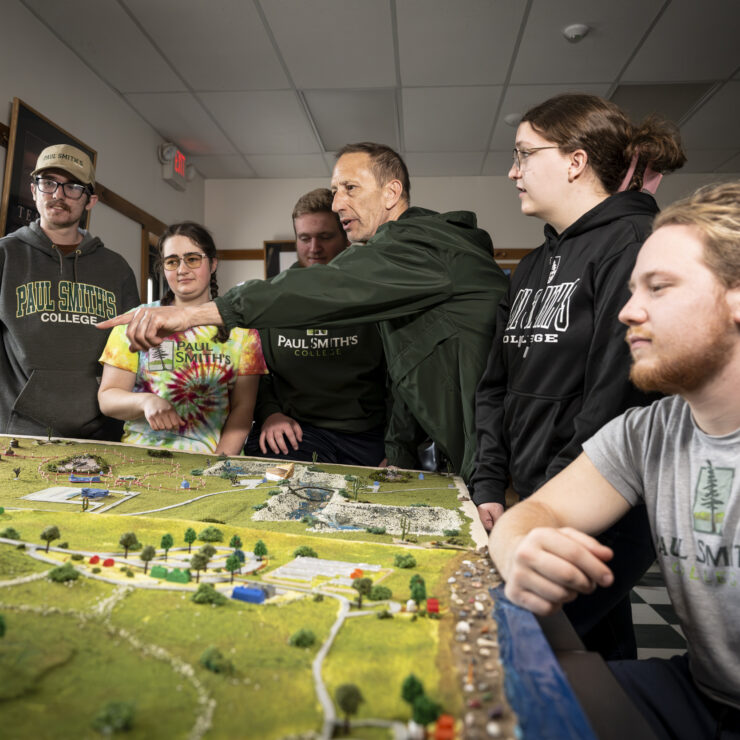 A group of people standing around a diorama table