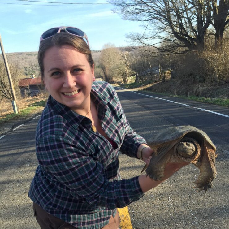 A woman holding a snapping turtle